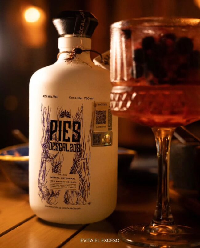 Pies Descalzos — El mezcal que se camina. El nombre nace de algo real: un maestro mezcalero subiendo un cerro, cargando garrafas vacías y...